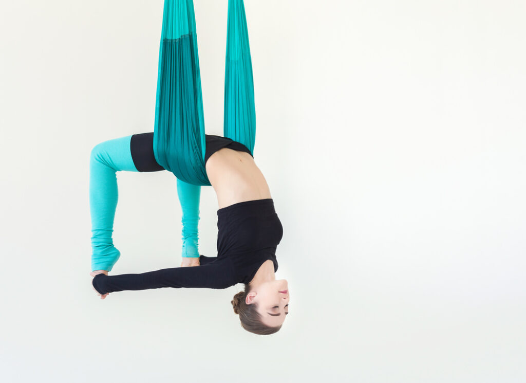 Woman practising canvases or hammock aerial yoga Vector Image