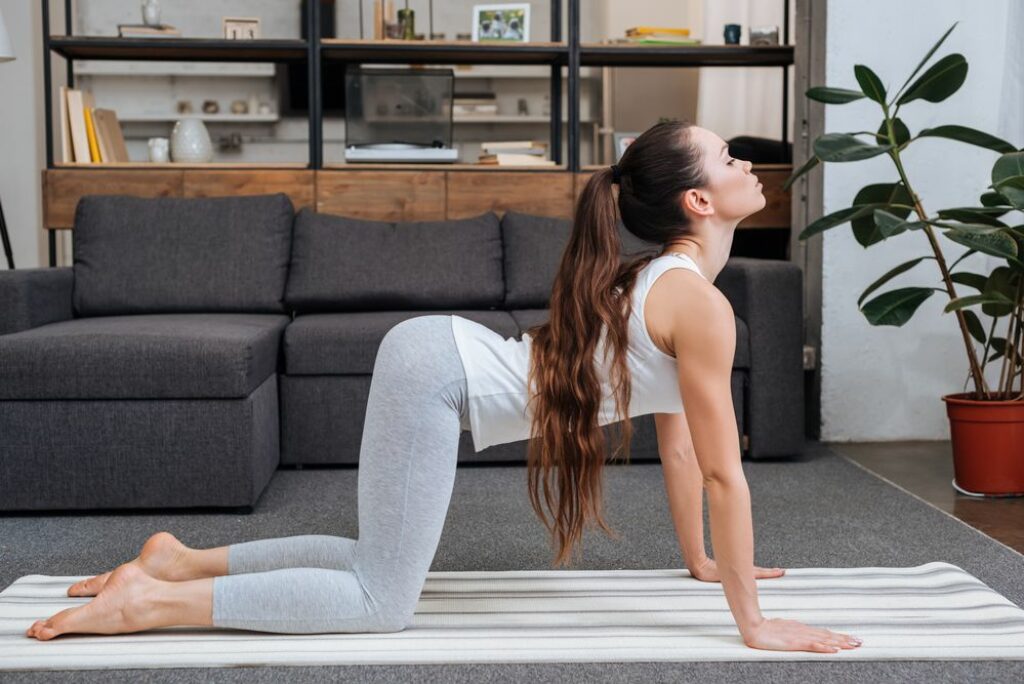 Woman doing cat cow yoga pose.