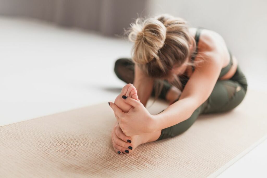 Woman doing head to knee yoga pose.