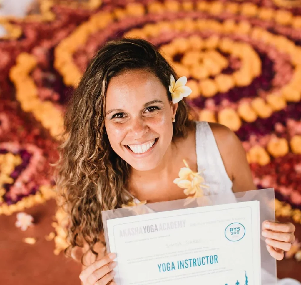 Image of Akasha Yoga Academy graduate holding her yoga teaching certificate. 