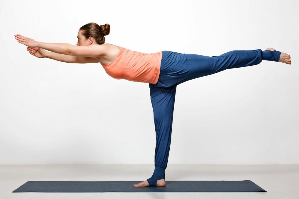 Woman doing warrior 3 yoga pose.