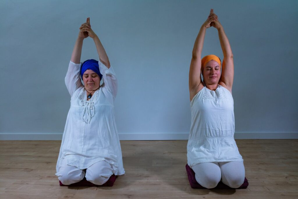 Two female yogis practicing Kundalini yoga.