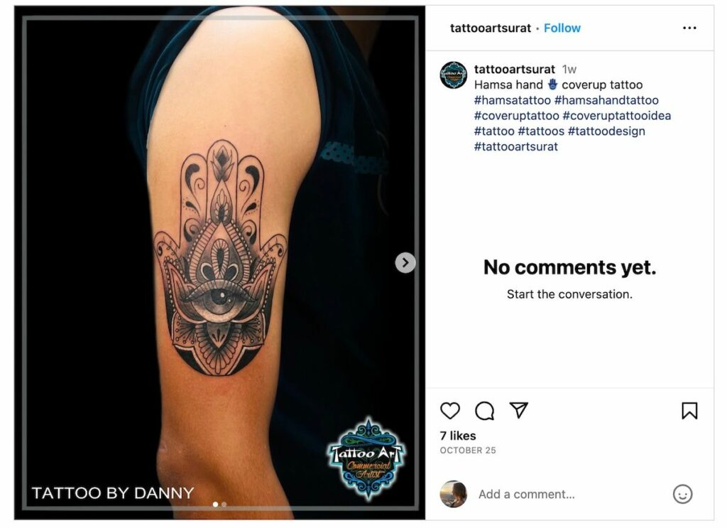 Hamsa hand tattoo on upper arm.