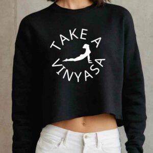 Female yogi wearing black funny yoga ladies' sweatshirt that says take a vinyasa.