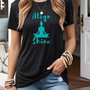 Female yogi with long hair wearing a casual black yoga graphic print t-shirt that says Align & Shine.