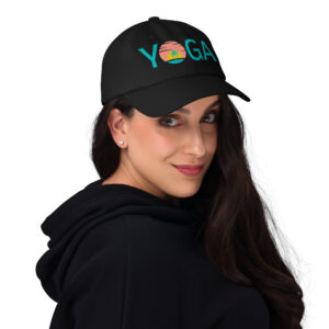 Woman with long black hair wearing a black trucker hat that says yoga and has a sunset graphic print.
