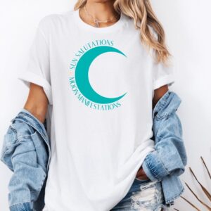 Female yogi with long hair wearing a casual white yoga t-shirt with Sun Salutations Moon Manifestations graphic print.