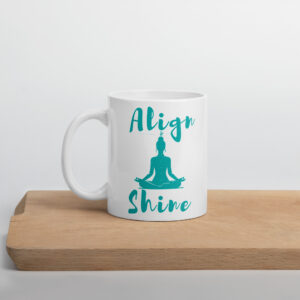 White ceramic yoga coffee cup with a graphic print design that says align and shine printed on both sides of the cup.