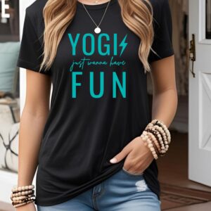 Female yogi with long hair wearing a casual black yoga graphic print t-shirt that says Yogis Just Wanna Have Fun.
