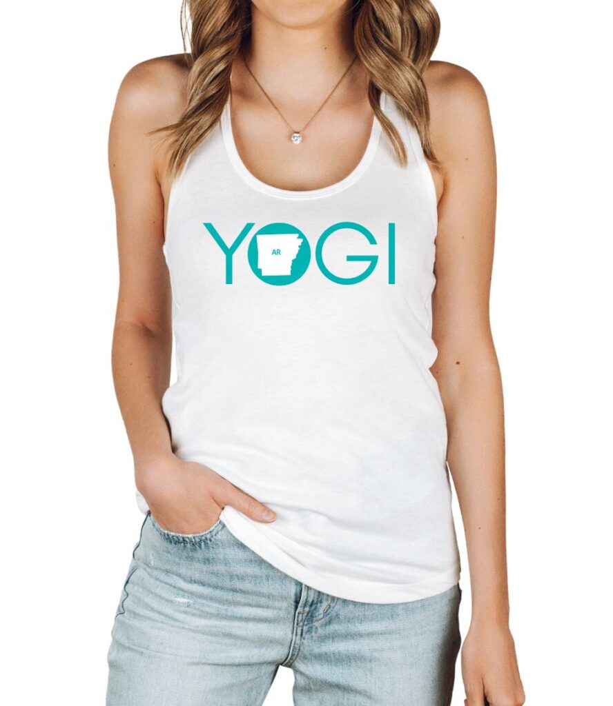 Female yogi with blonde hair wearing a white racerback yoga tank top with a graphic of Arkansas State and the word yogi.